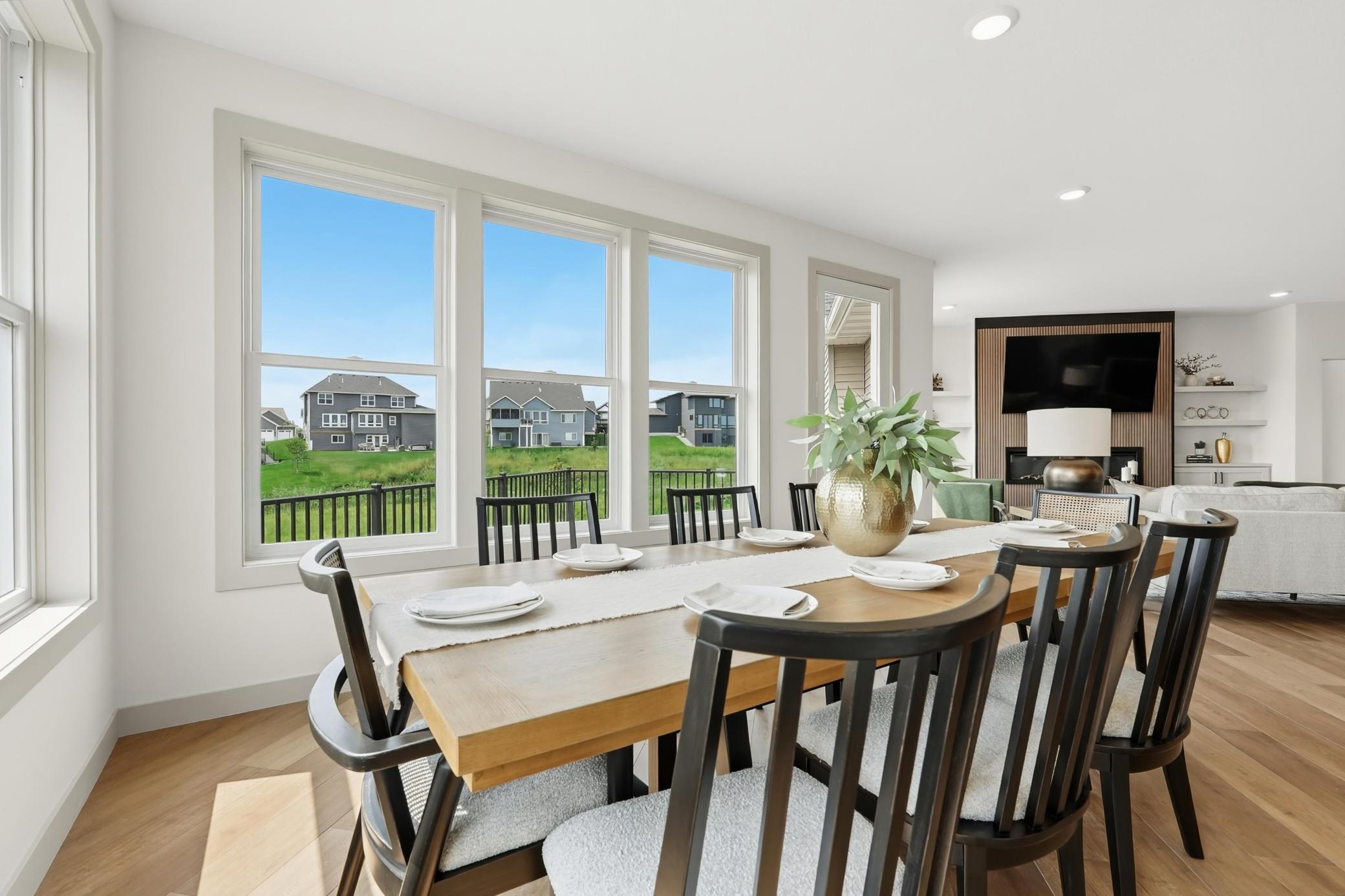 Dining Room
Light-filled dining room situated adjacent to the kitchen, framed by a massive triple-window bank overlooking green open spaces and providing a scenic backdrop for meals.