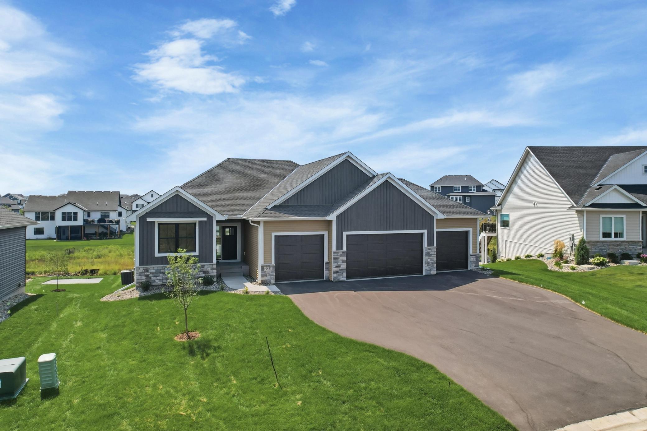 Modern Elevation & Multi-Car Garage
Striking modern exterior featuring a sophisticated combination of charcoal board-and-batten siding, warm stone accents, crisp white trim, and an expansive driveway leading to an attached multi-bay garage.