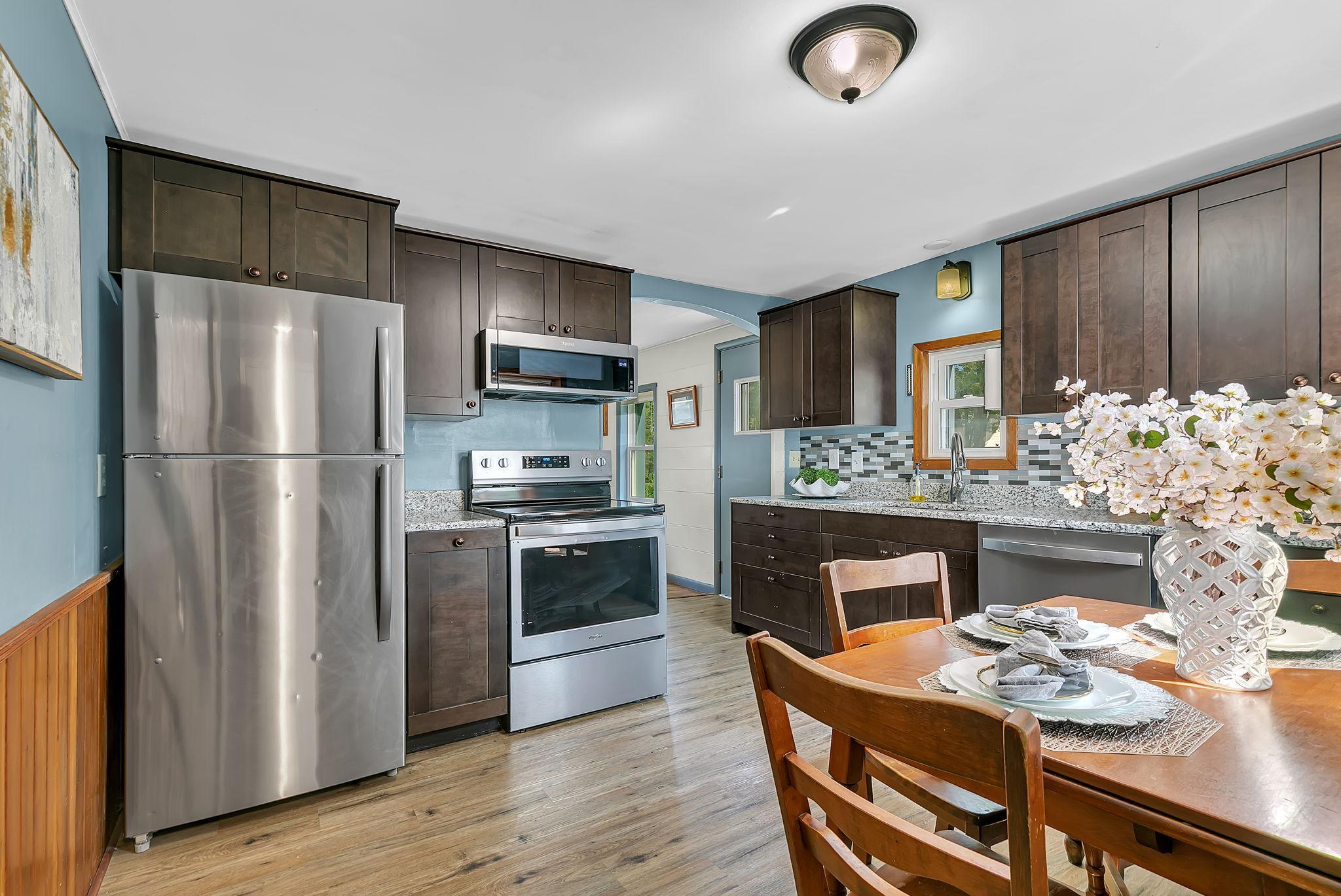 An updated kitchen in 2020, featuring granite counters, new cabinetry and ss appliances!