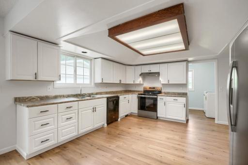 The spacious, newly renovated kitchen is designed for both everyday living and entertaining, featuring abundant cabinetry and countertop space, updated finishes, and new flooring.