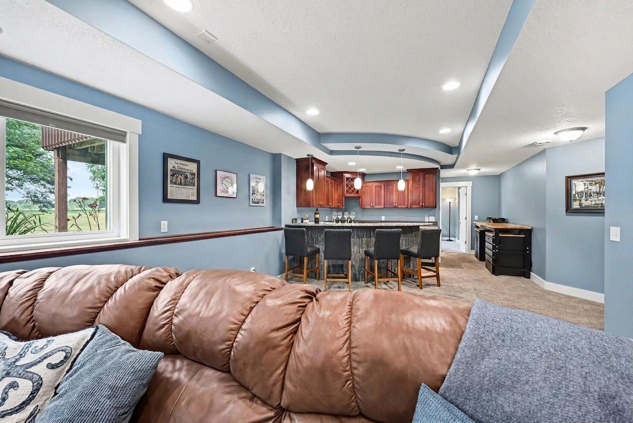 Lower-level entertaining space with wet bar visible