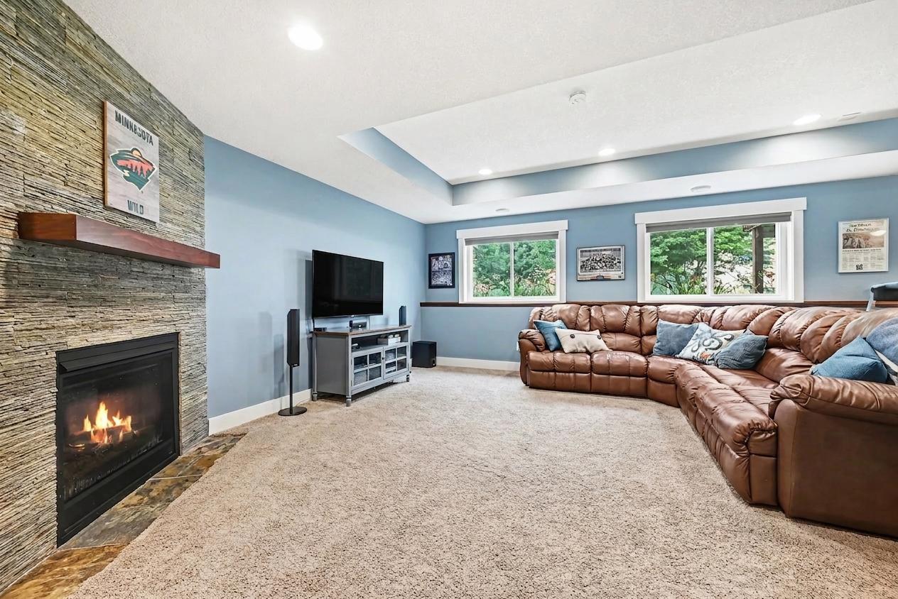 Finished lower-level family room with stone gas fireplace