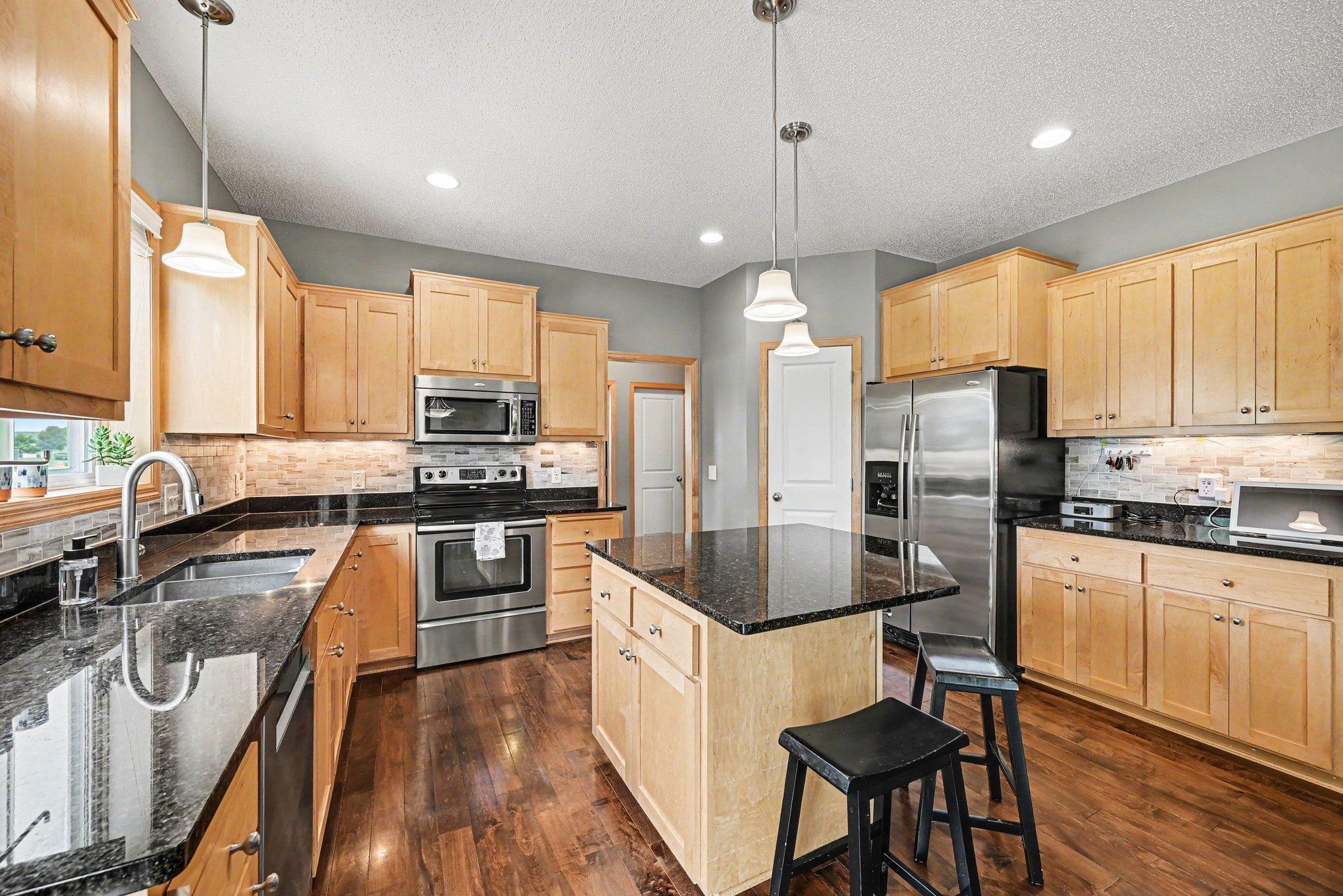 Center-island kitchen with granite counters and stainless steel appliances