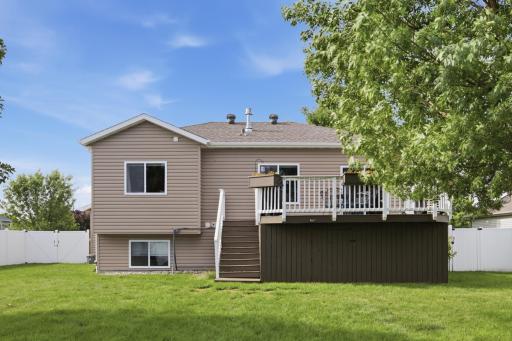 Rear Exterior - large backyard has large deck with storage underneath, maintenance free fence, and shed
