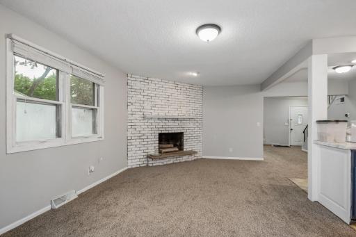 Lovely open dining room with wood burning fireplace and access to kitchen.