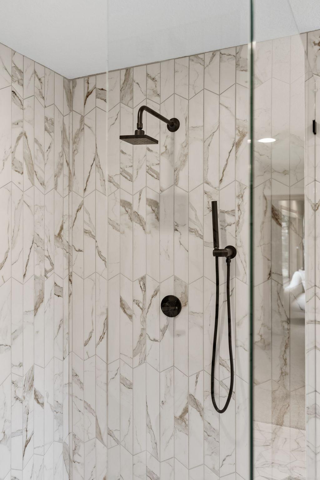 New primary shower with black plumbing fixtures and frameless glass.