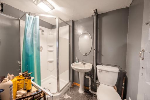 Bright lower level bathroom with corner shower and pedestal sink!