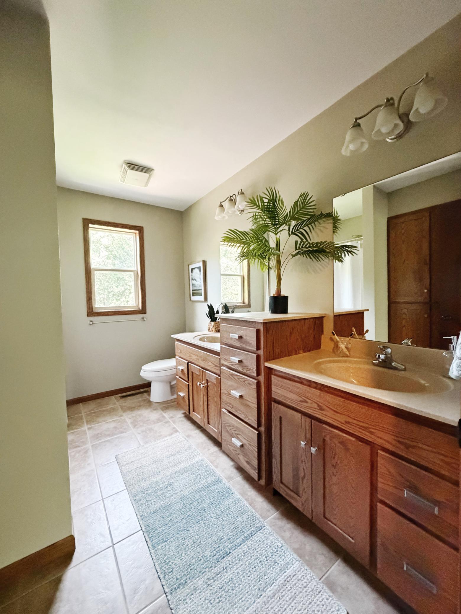 Large full bathroom featuring dual sinks in upper level