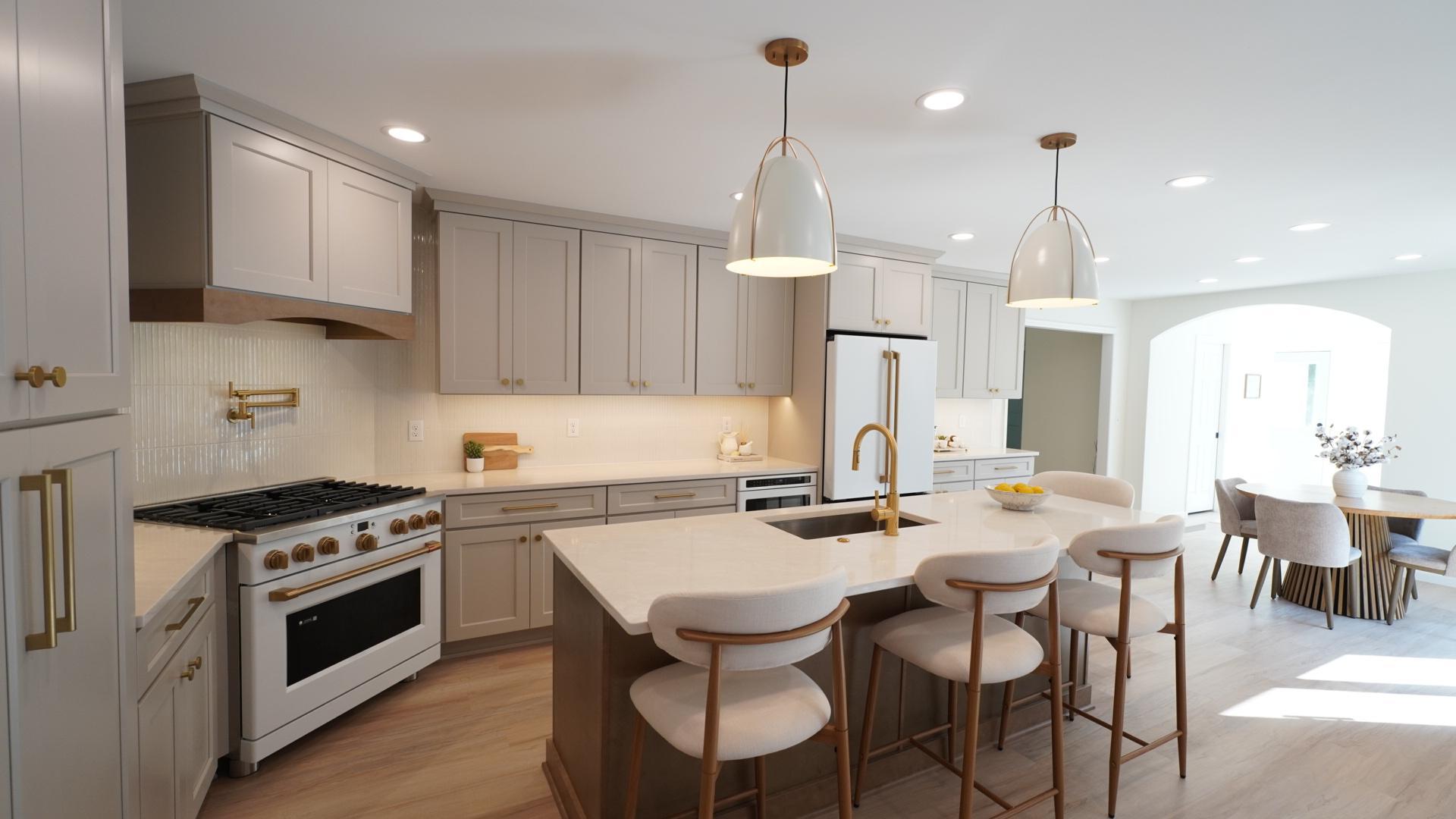 The large chef's kitchen accommodates large and small gatherings with an 8.5' island and luxurious touches including Aurataj quartz countertops, CAFE' appliances, a pot filler over an extra-wide commercial stove, ample light, and much more.