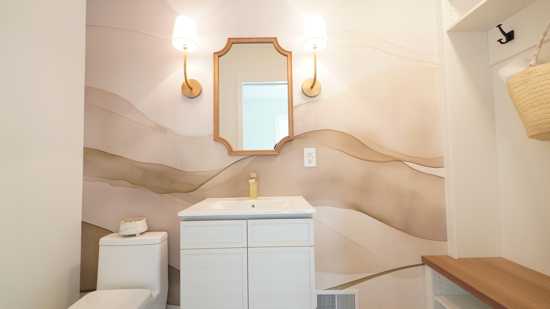 The brand new main level powder room near the patio features a custom wallpaper accent mural and a changing area perfect for guests using the private pool.
