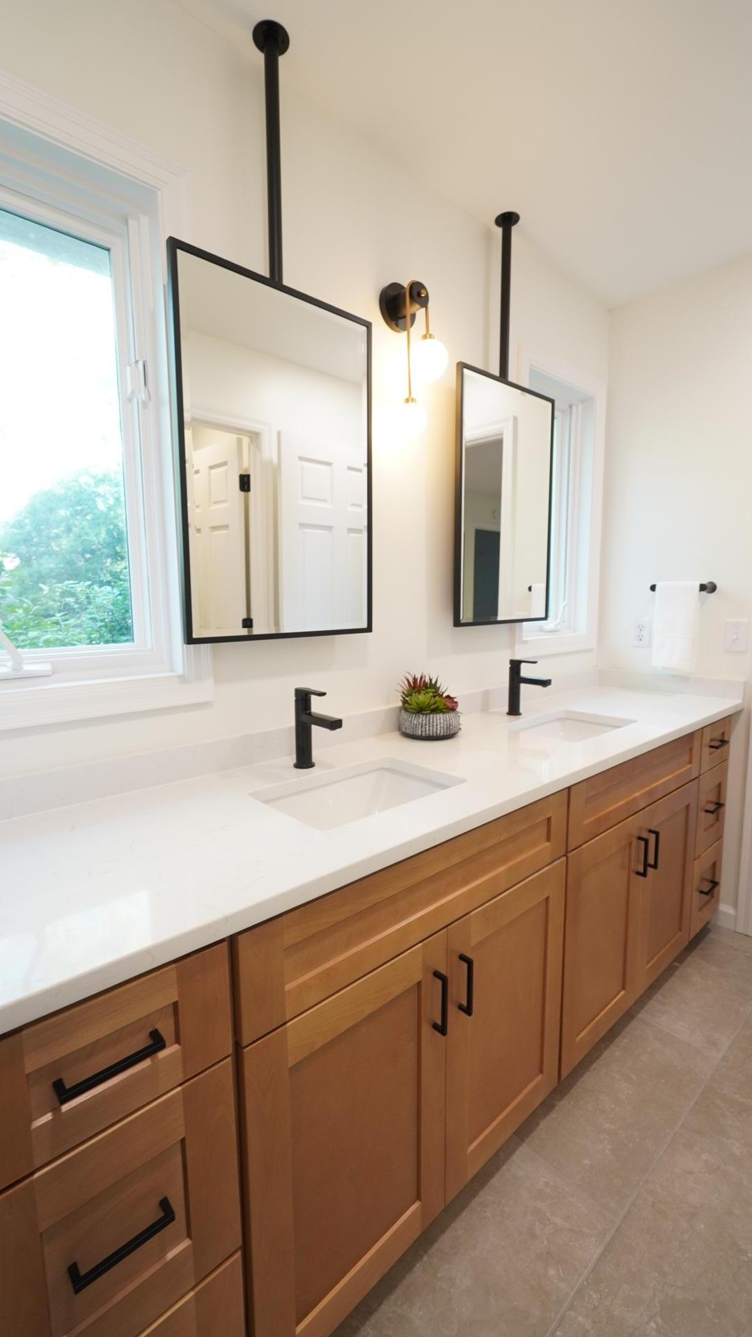 The Jack and Jill bath between bedrooms 3 and 4 provides ample counter space on the custom double vanity and ample light from windows that are enhanced by the sleek, ceiling-mount mirrors. Not pictured is a separate shower room.
