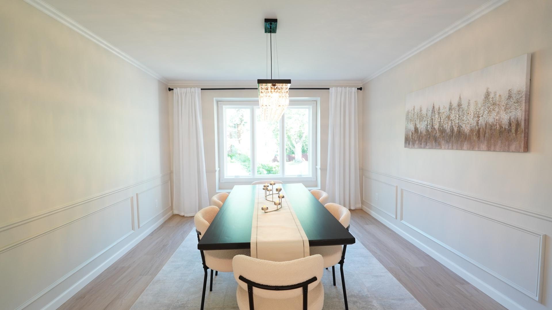 The large formal dining room has several features that set this room apart including a large bay window, decorative wainscoting and a gorgeous crystal chandelier.