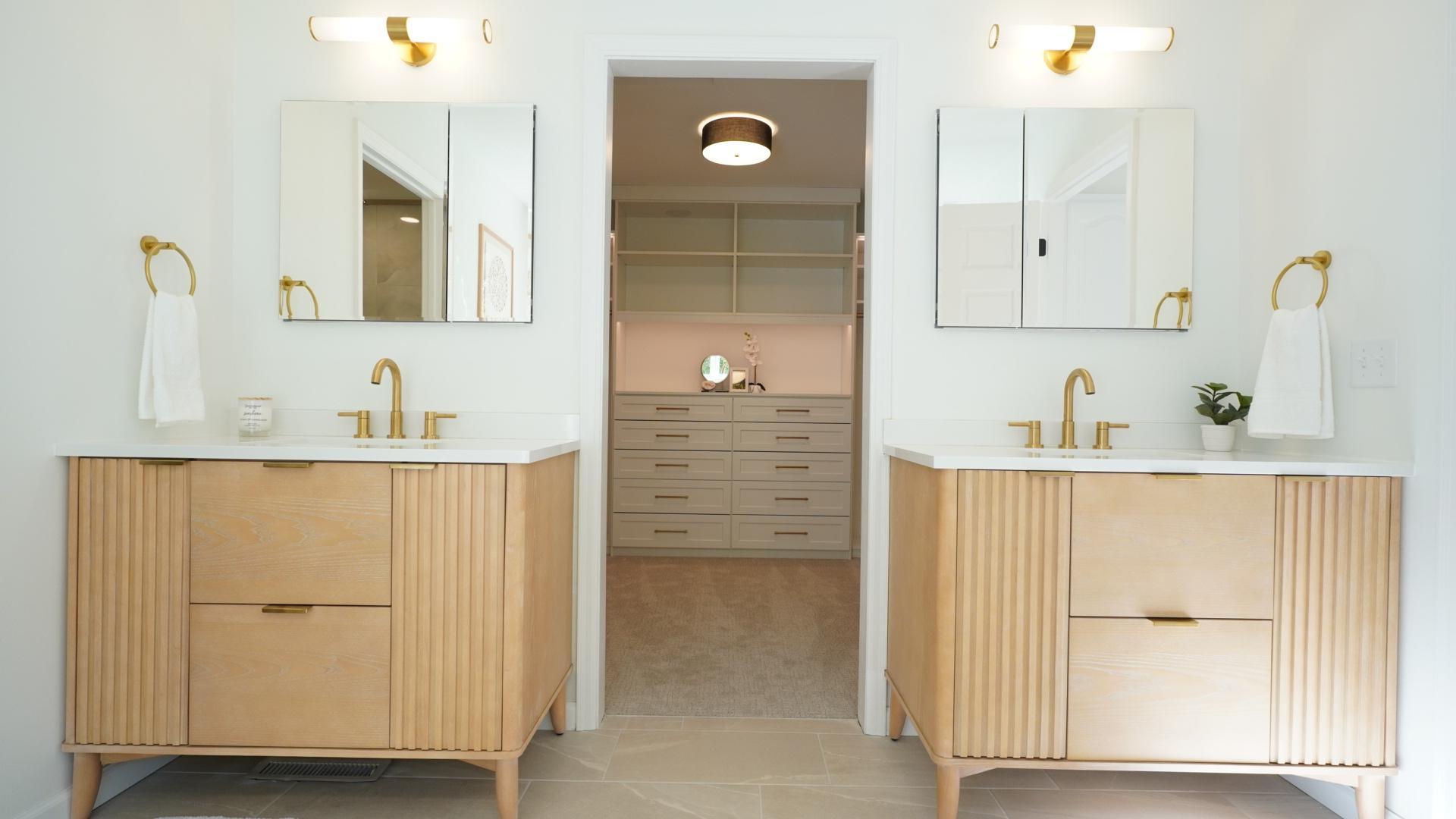 The separate, designer vanities and large medicine cabinets flank an oversized walk-in closet with custom cabinetry that includes subtle, indirect lighting.