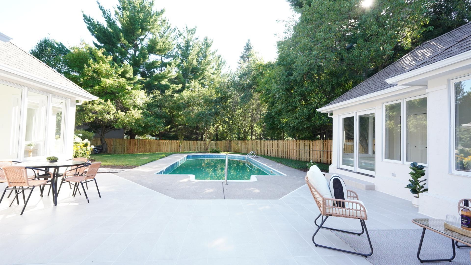 The large, newly tiled patio orients toward an in-ground pool with a brand new filtration system. The back yard is enclosed by a completely new wood shadow box fence with two latching gates.