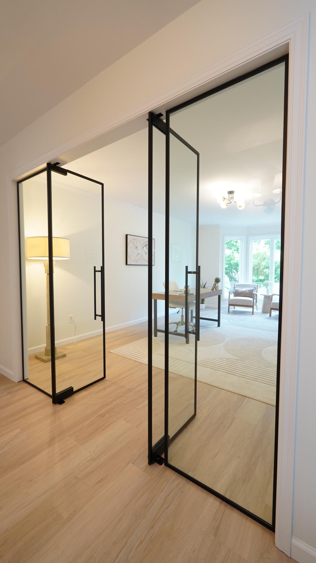 The sizable office offers privacy without blocking out natural light with the installation of these custom, full height, tempered and substantial glass doors in a modern design.