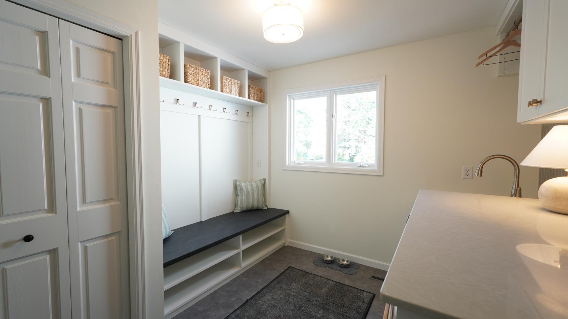The main level mudroom and laundry room boasts custom cabinetry, new flooring, a quartz countertop and a ton of storage. The variety of storage options makes the perfect drop zone upon entering the home from the garage.