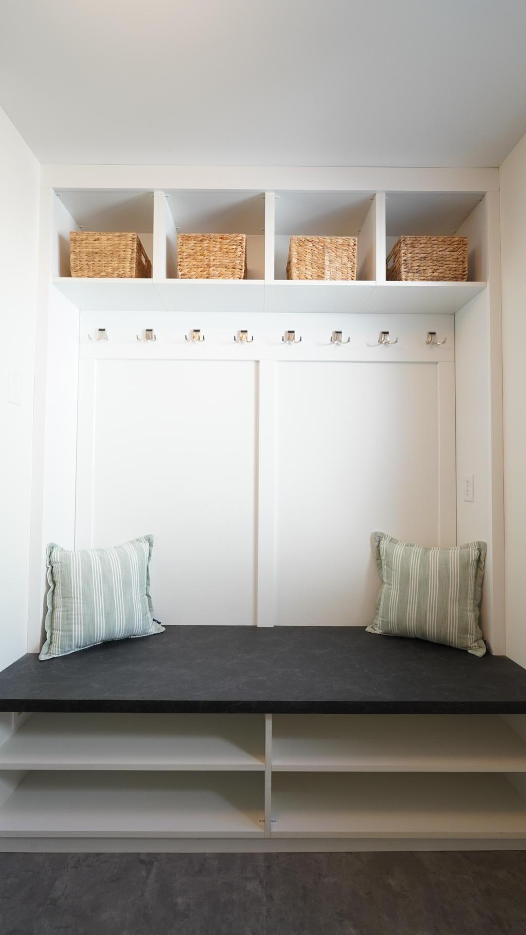 The mudroom large bench seating area's custom cabinetry offers a ton of storage perfect for a family.