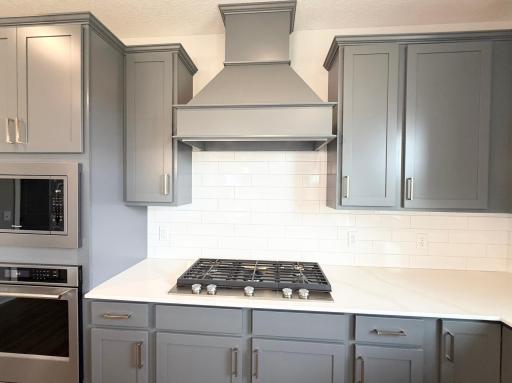 Picture of Actual Home: Large 5 burner cooktop with a beautiful wood hood.