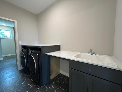 Laundry room with utility sink and storage