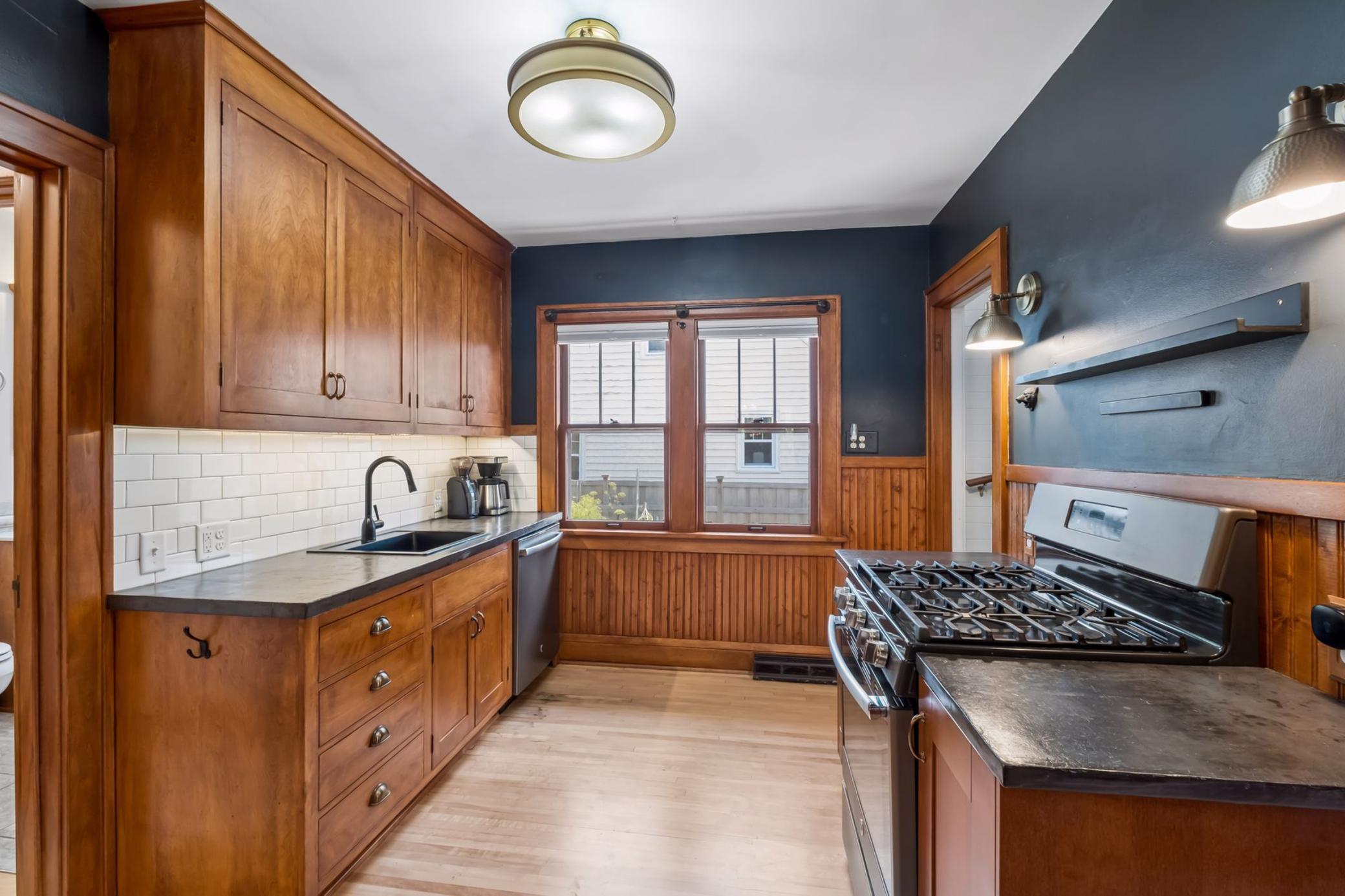 The kitchen features refaced cabinetry, subway tile backsplash, and stainless appliances.