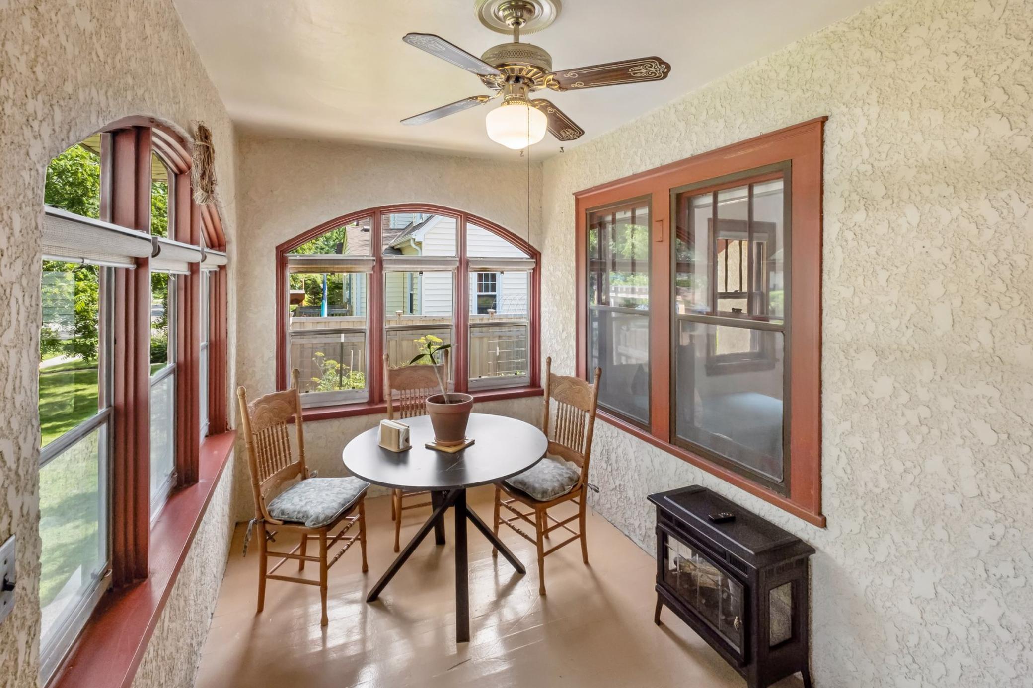 Warm and welcoming east facing front porch with stucco walls and dual arched windows.