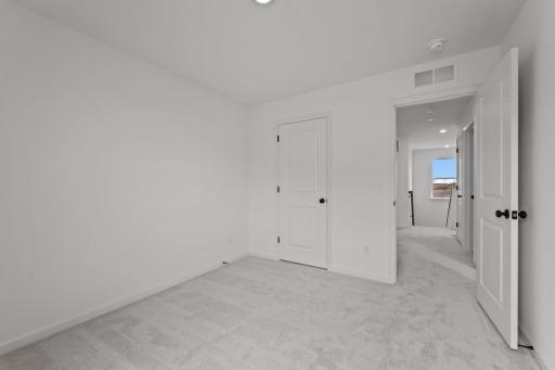 Comfortable secondary bedroom in the McBee plan ideal for guests or family use. Images are from a similar home, interior selections may differ