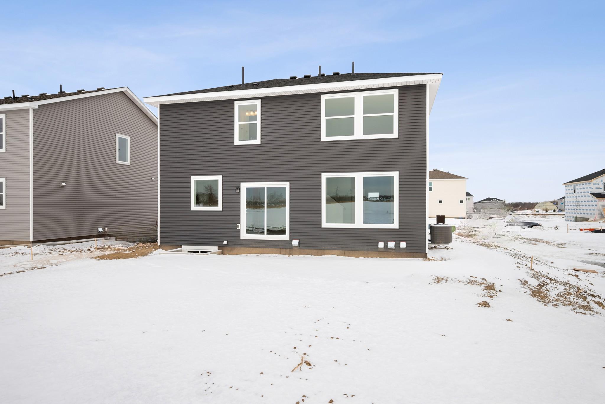 The rear exterior showcases a clean, modern elevation with multiple windows that bring natural light into the home. Images of similar home, interior selections differ.