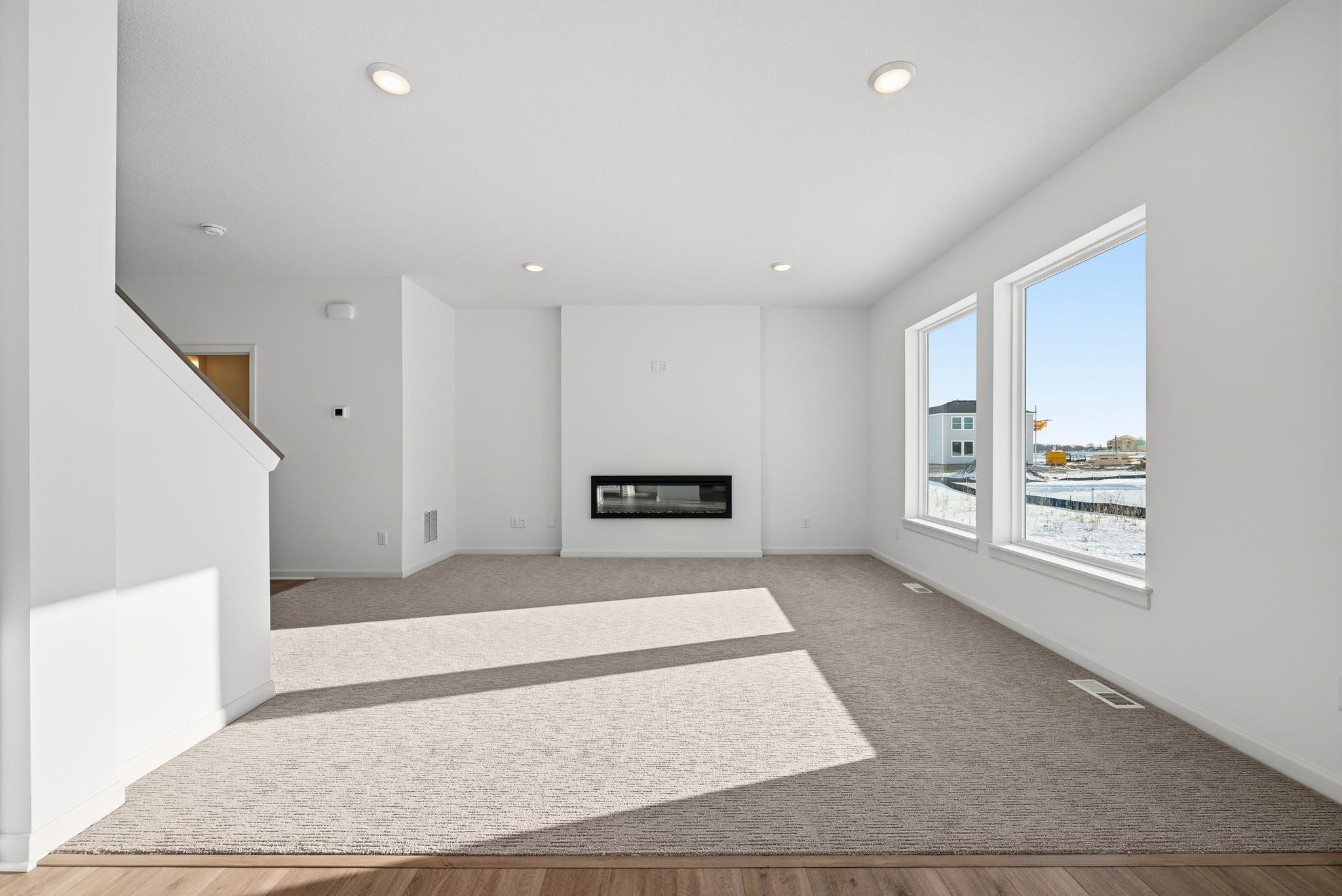 The main living space is bright and welcoming, featuring large windows that bring in abundant natural light. Images of similar home, interior selections differ.