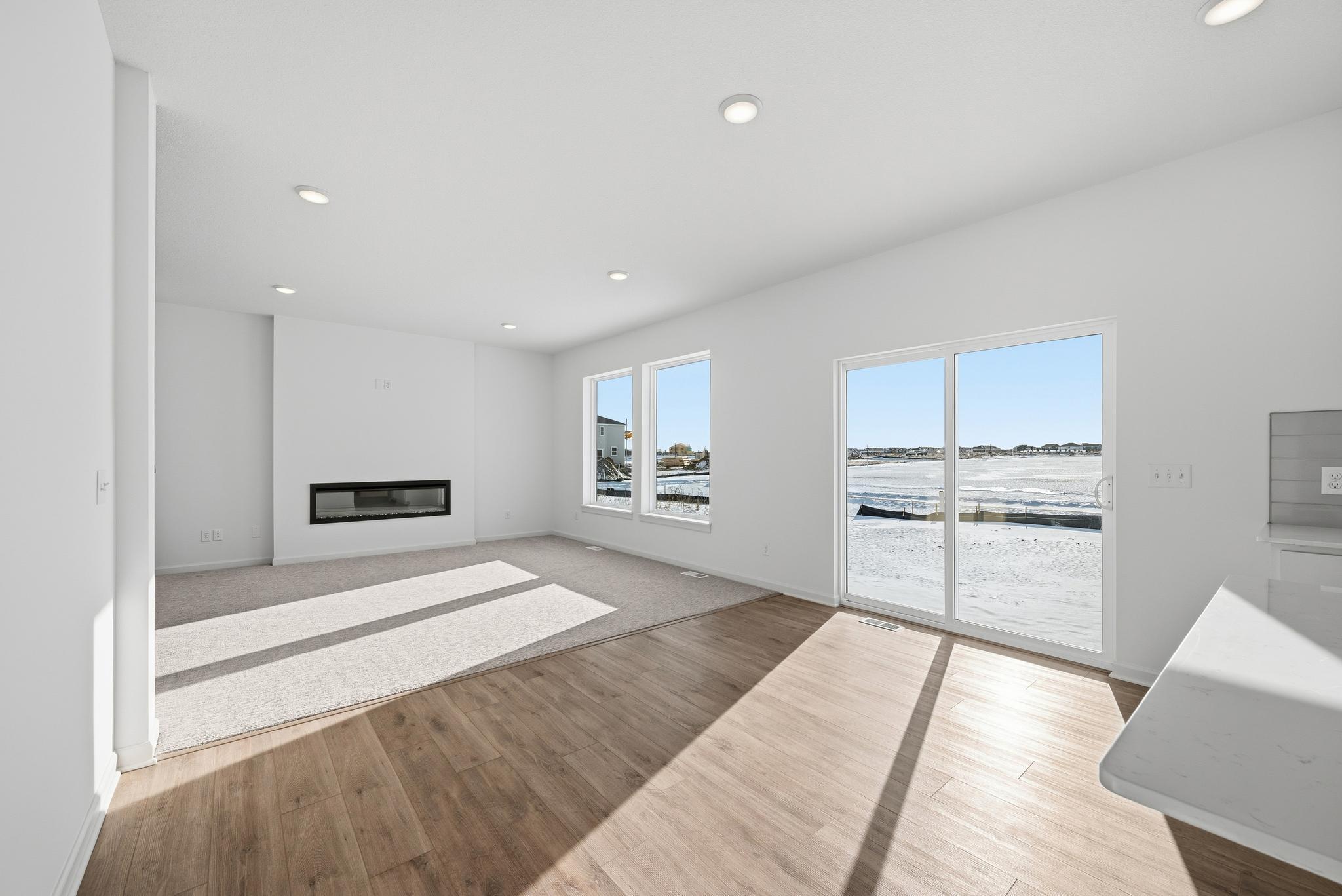 The main living space is bright and welcoming, featuring large windows that bring in abundant natural light. Images of similar home, interior selections differ.