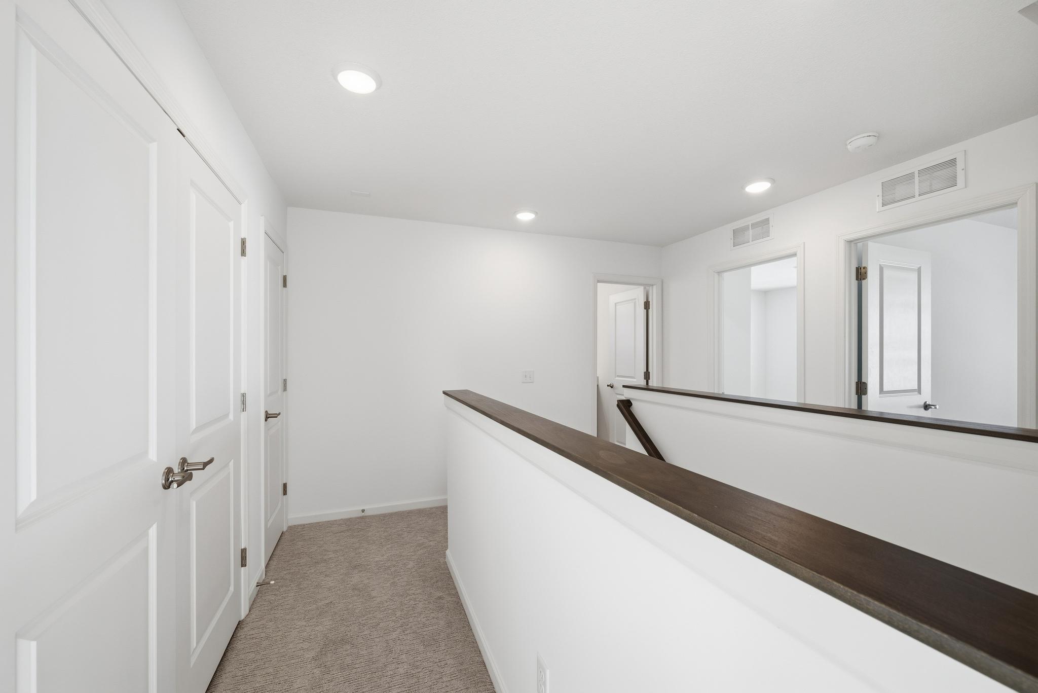 This upper-level hallway offers a bright, open feel. Images of similar home, interior selections differ.