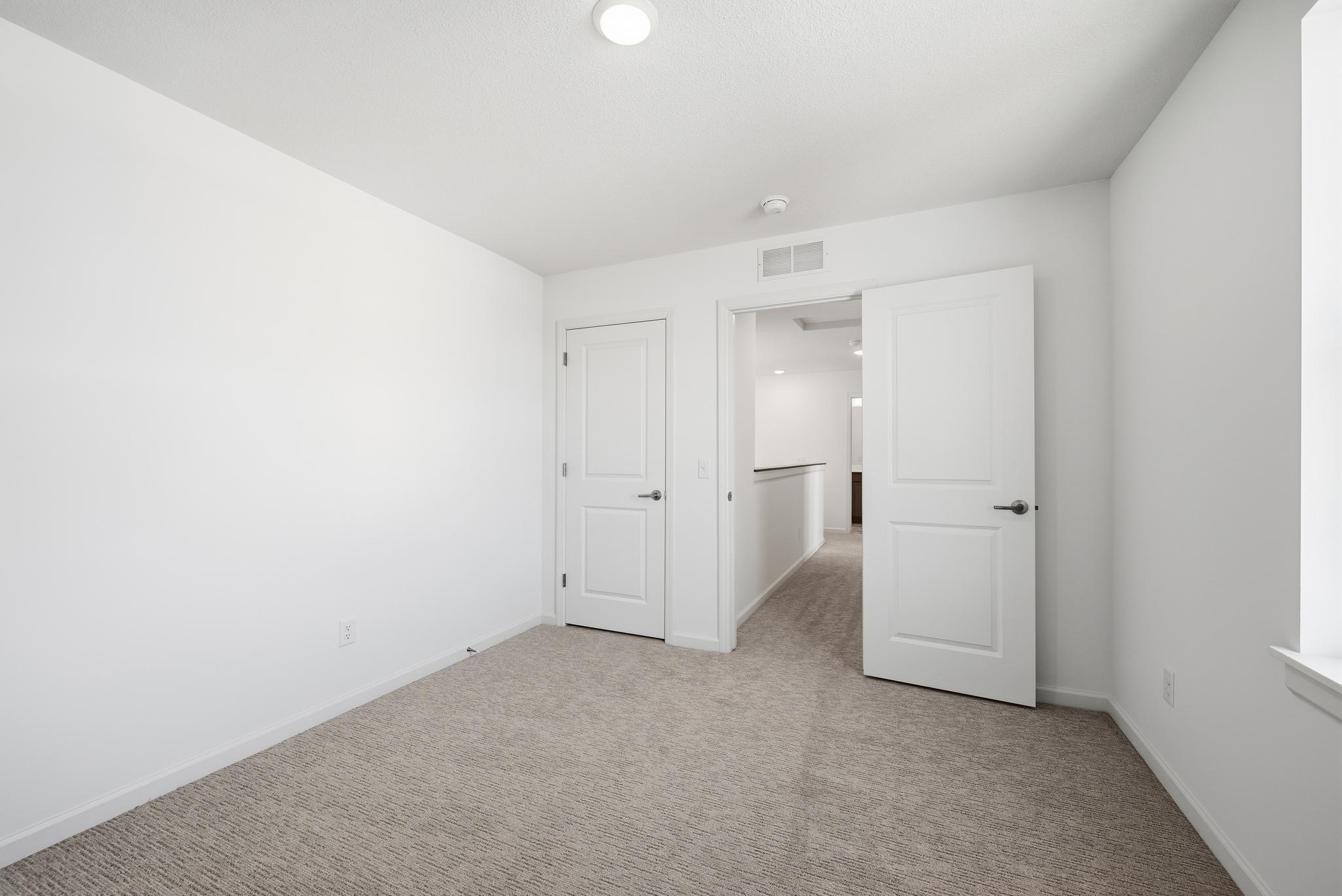 This secondary bedroom features a comfortable layout with well-placed windows, allowing natural light to brighten the space. Images of similar home, interior selections differ.