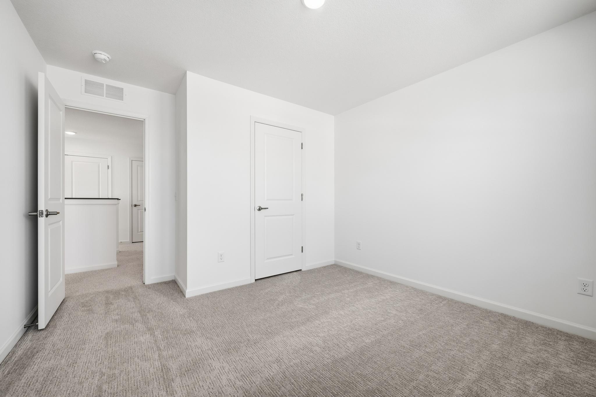 This secondary bedroom features a comfortable layout with well-placed windows, allowing natural light to brighten the space. Images of similar home, interior selections differ.