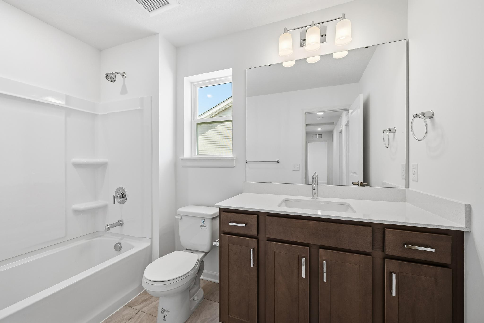 The secondary bathroom is designed with efficiency and comfort in mind. Images of similar home, interior selections differ.
