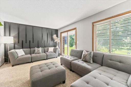 Natural light illuminates the room through large window and patio door.