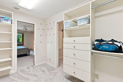 Primary walk-in closet with pocket door leading to the laundry room