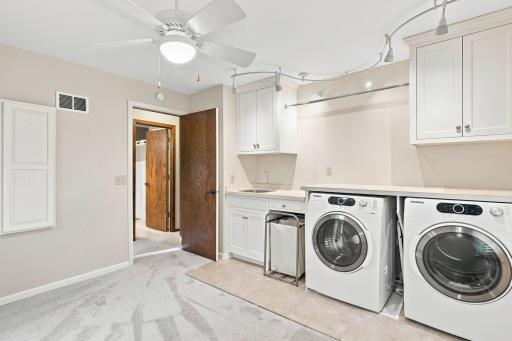 Spacious upper level laundry room with folding area and storage