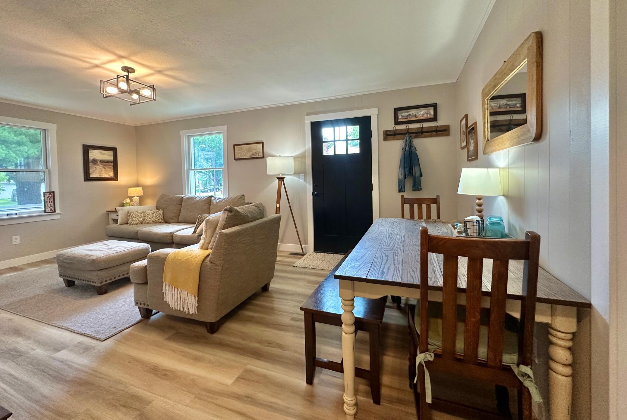 A look at the front entry and the cozy living room that has good natural lighting.