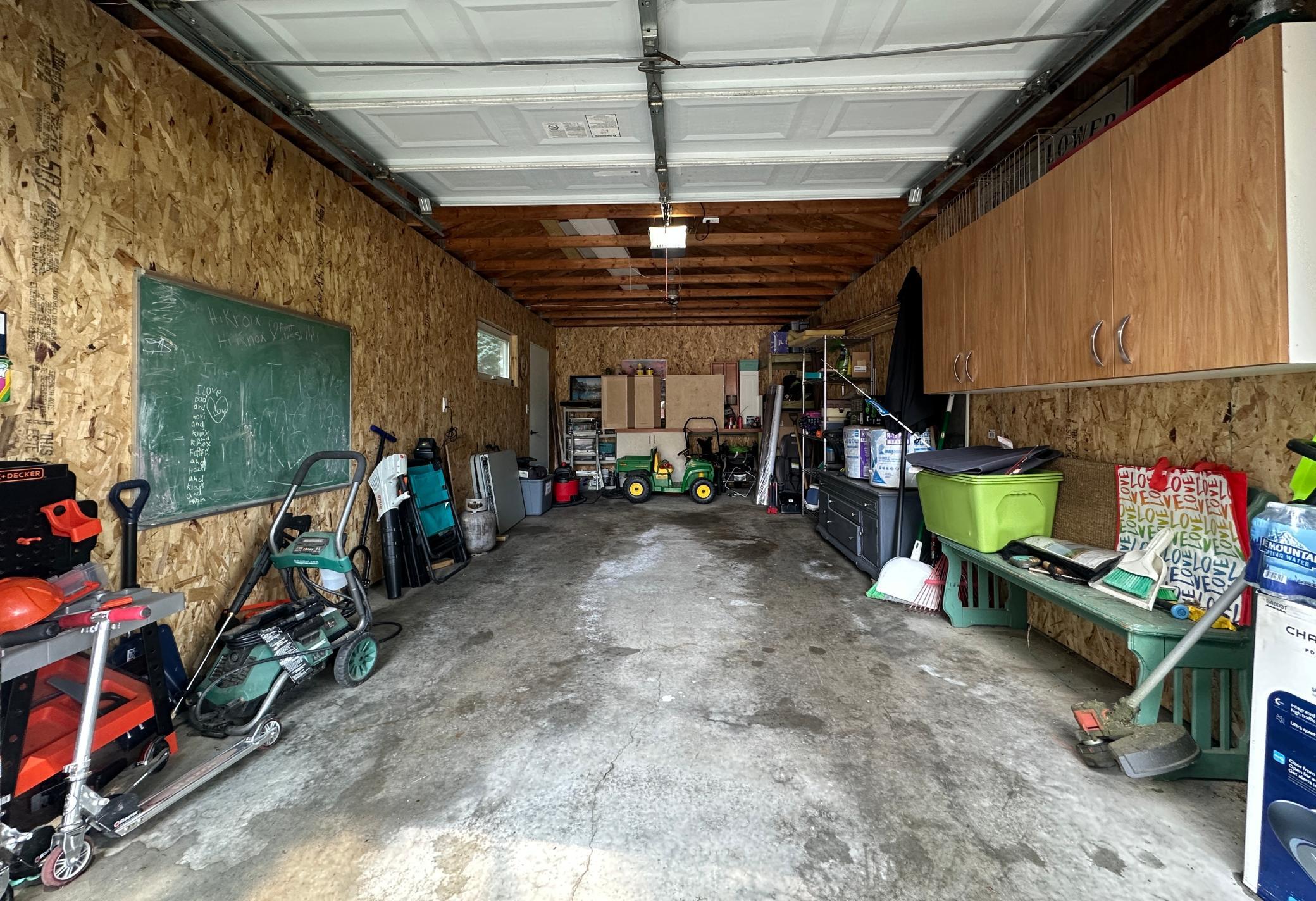The garage has extra space and cabinets and was recently sheeted with chip board.