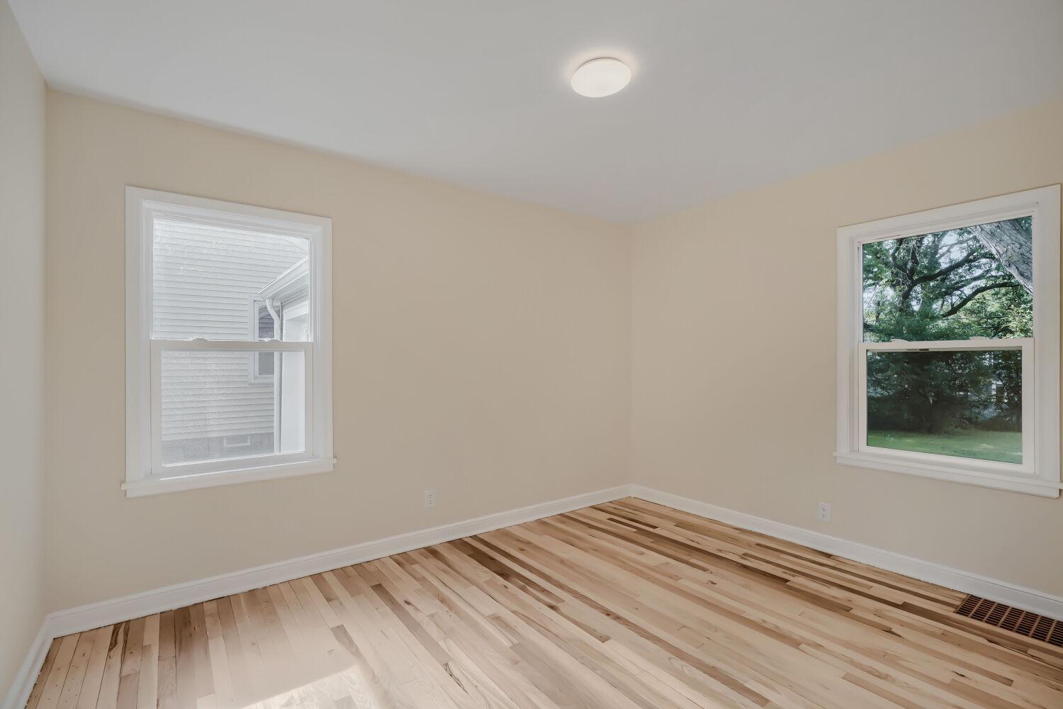 7711 Division St - 2nd bedroom on main level is painted warm hues to match living room.