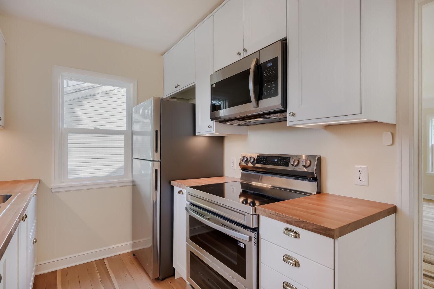 7711 Division St - Making dinner is a breeze with all new stainless-steel appliances, hidden dishwasher, and ample storage.