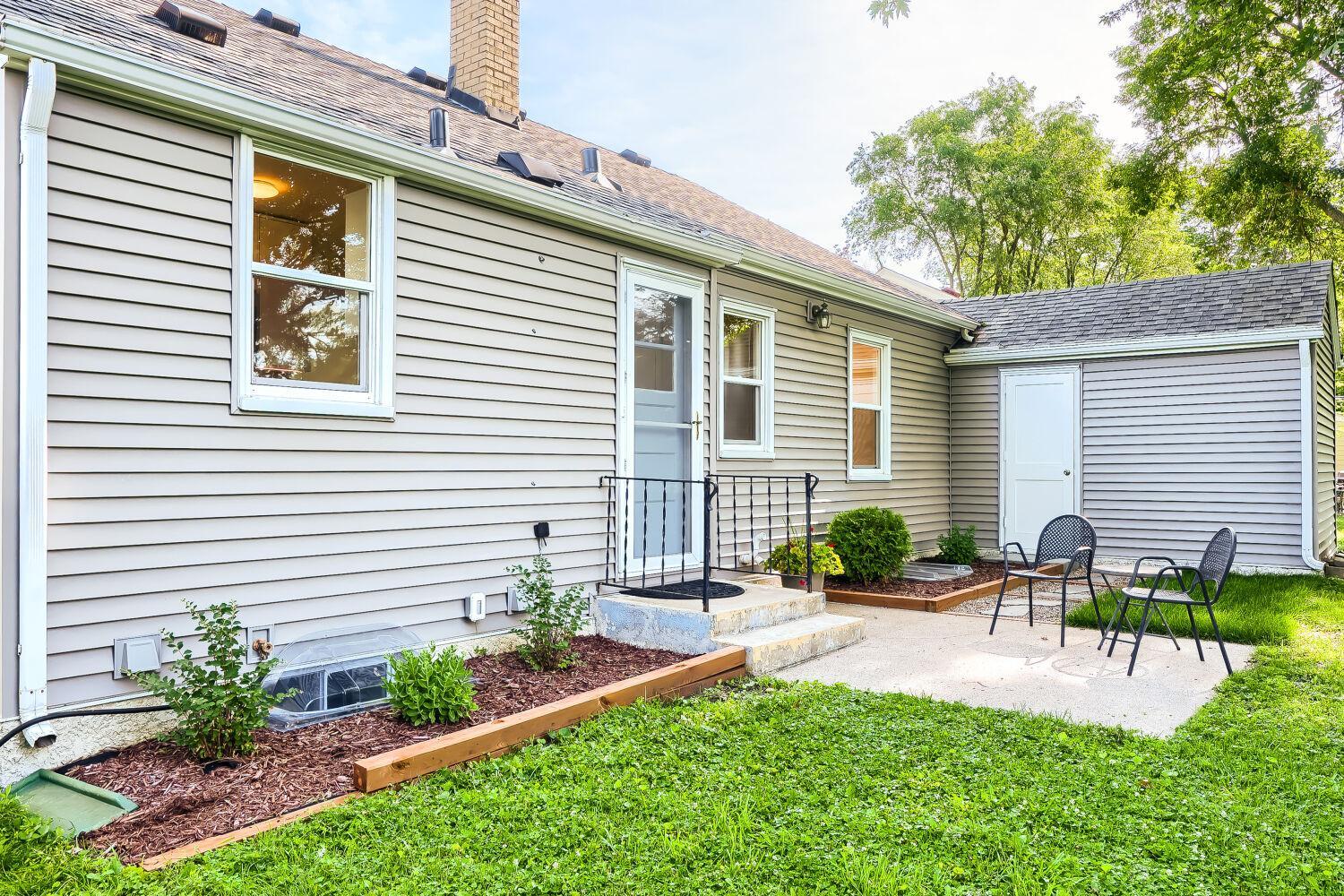 7711 Division St - Step outside to relax on the patio with fresh landscaping, a mini plum orchard and mature trees.