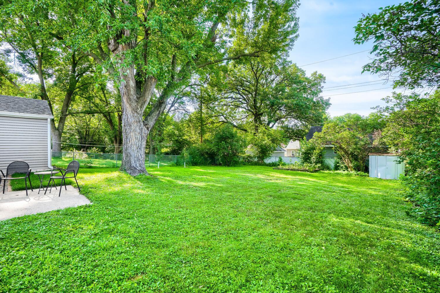 7711 Division St - The large backyard is flat and fully fenced - perfect for entertaining, gardening, pets or play. Check out the raised garden bed, storage shed, new garage door with opener, and secure locking side entry.