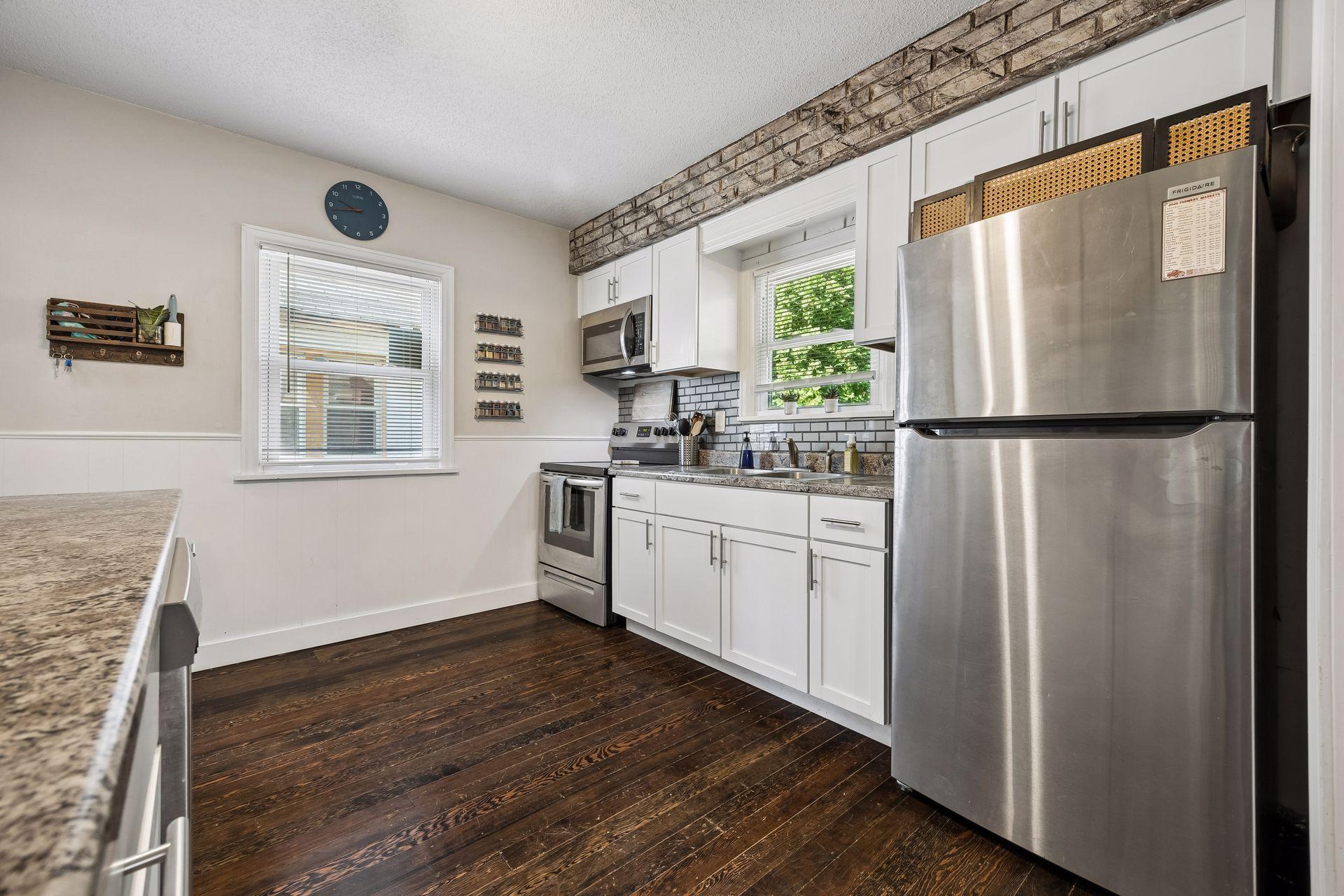 Updated and move-in ready. The bright kitchen features white cabinetry, new stainless steel appliances, generous prep space, and a seamless connection to the dining room.