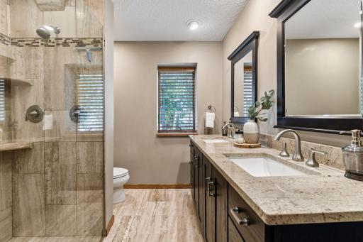 Ensuite bath off of lower level bedroom provides large tiled shower and double vanity