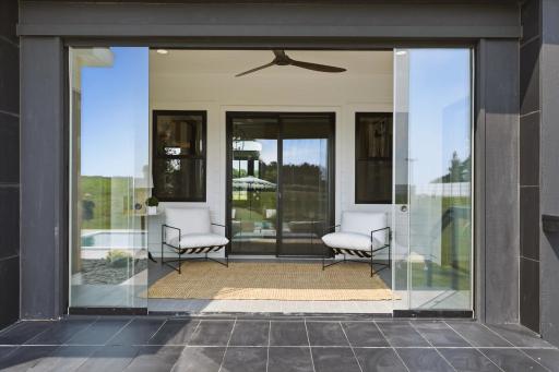 retractable glass wall to create and indoor-outdoor experience from this sunroom connecting the home to the pool and patio