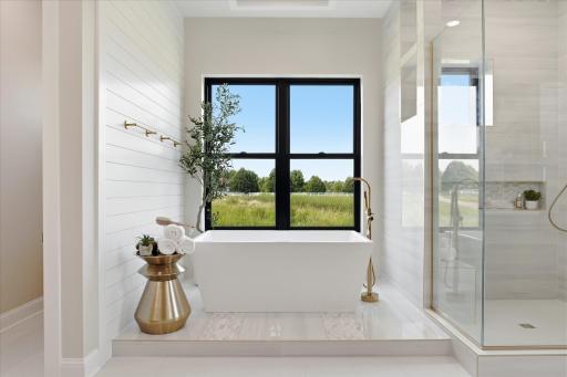 Spa-inspired with separate vanities, soaking tub, and tiled walk-in shower