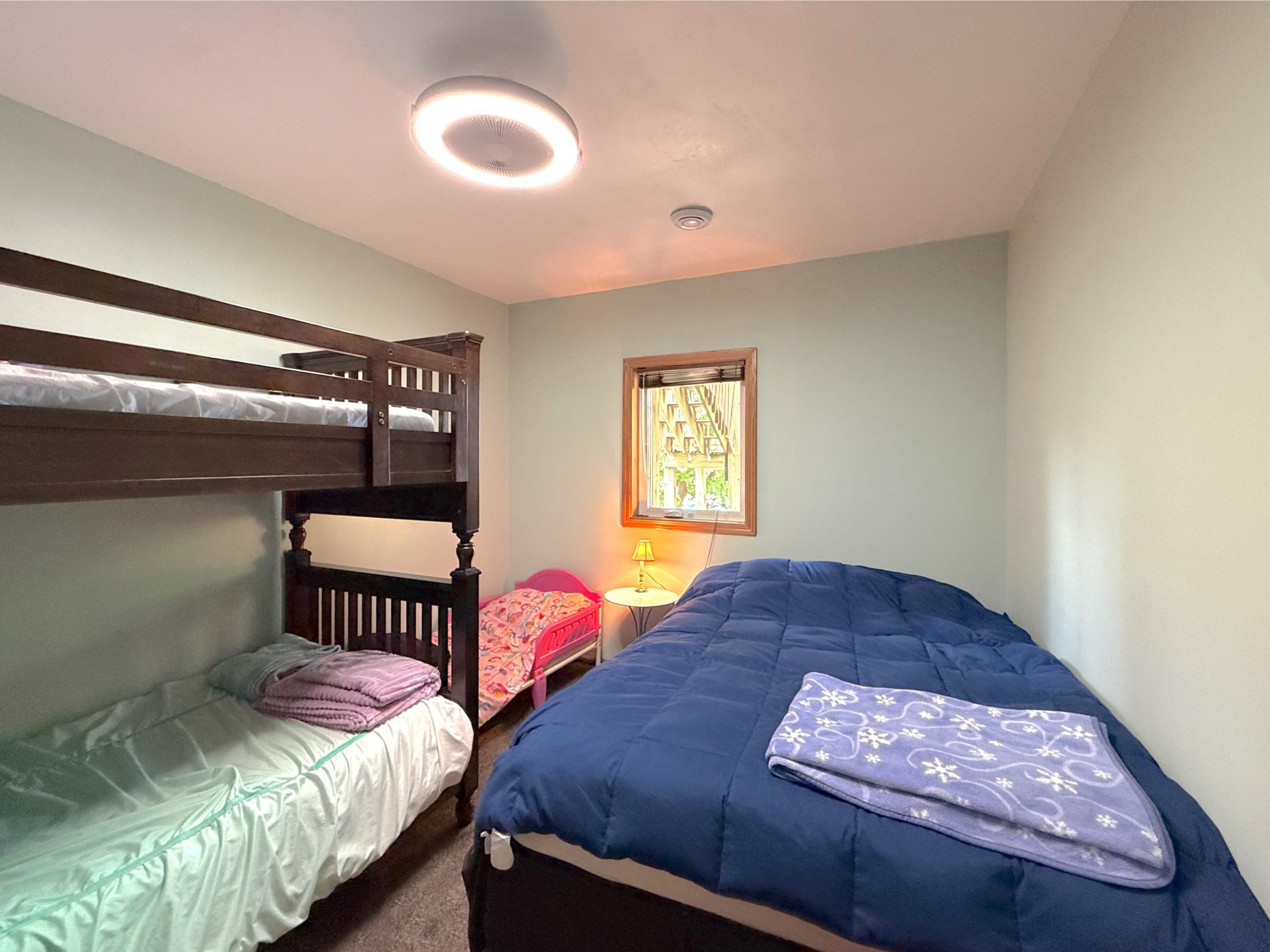 The spacious lower-level bedroom is filled with natural light, creating a bright and comfortable retreat for family or guests offering lake views.