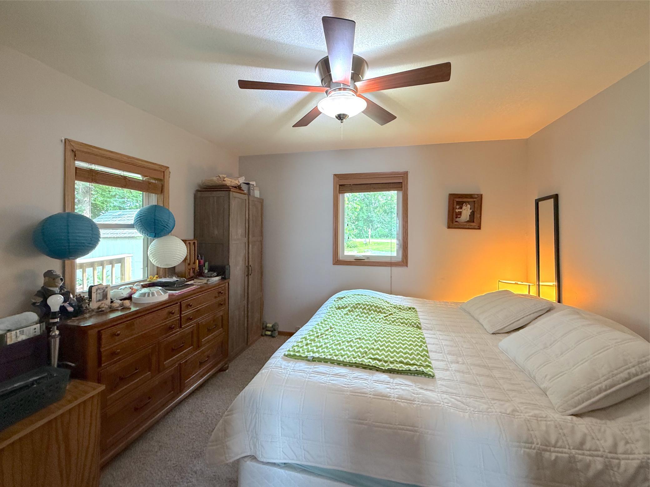 The spacious primary bedroom offers a peaceful retreat with abundant natural light, plush carpeting, and views of the surrounding greenery.