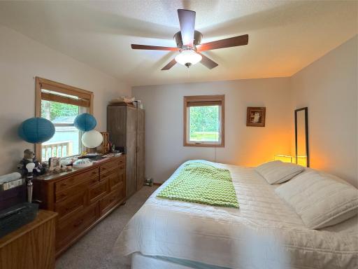 The spacious primary bedroom offers a peaceful retreat with abundant natural light, plush carpeting, and views of the surrounding greenery.