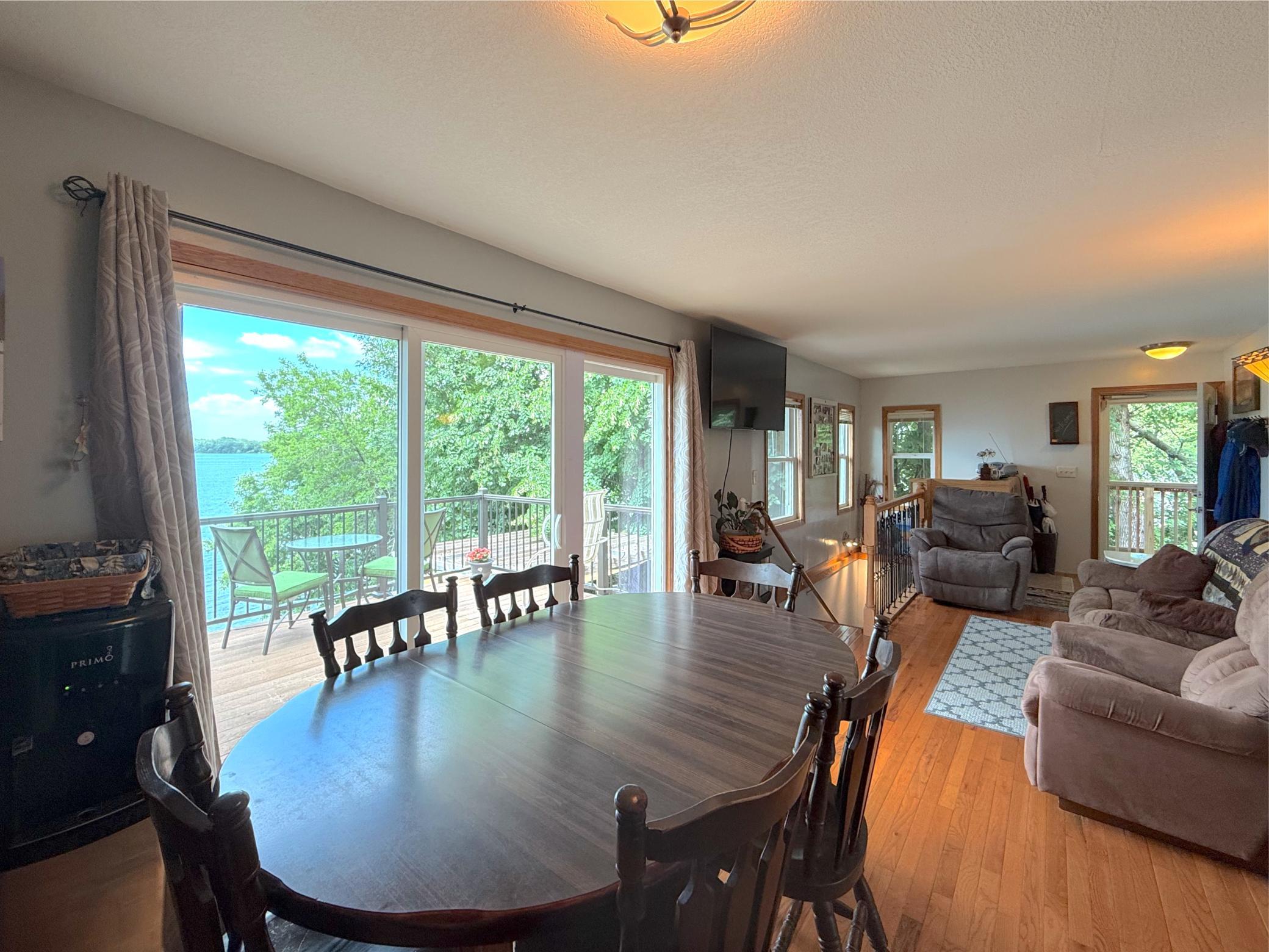 Warm hardwood floors, a spacious kitchen, and sliding glass doors leading to the outdoor deck offering stunning views of Lake Francis.